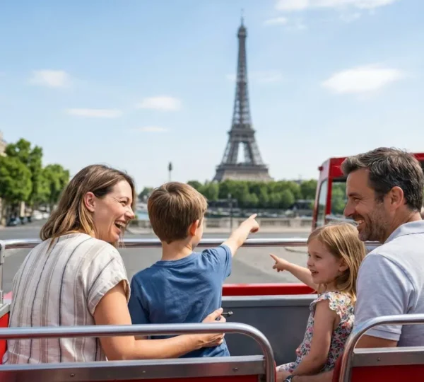 Family of four on the open-top deck of a red double-decker bus in Paris, with two children pointing excitedly toward landmarks while parents sit relaxed nearby